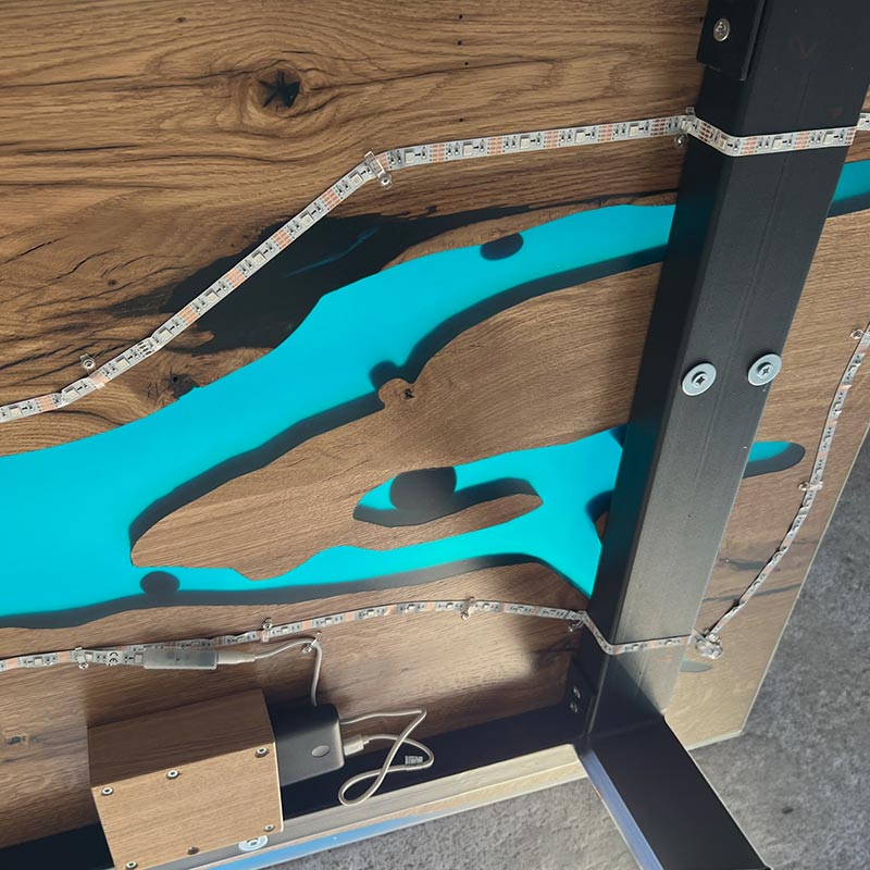 Epoxy Tisch. Detailbild der Befestigung der Beleuchtung Epoxidharz Tisch aus rustikaler Eiche. Modell Bodensee von Schwarzhirsch.