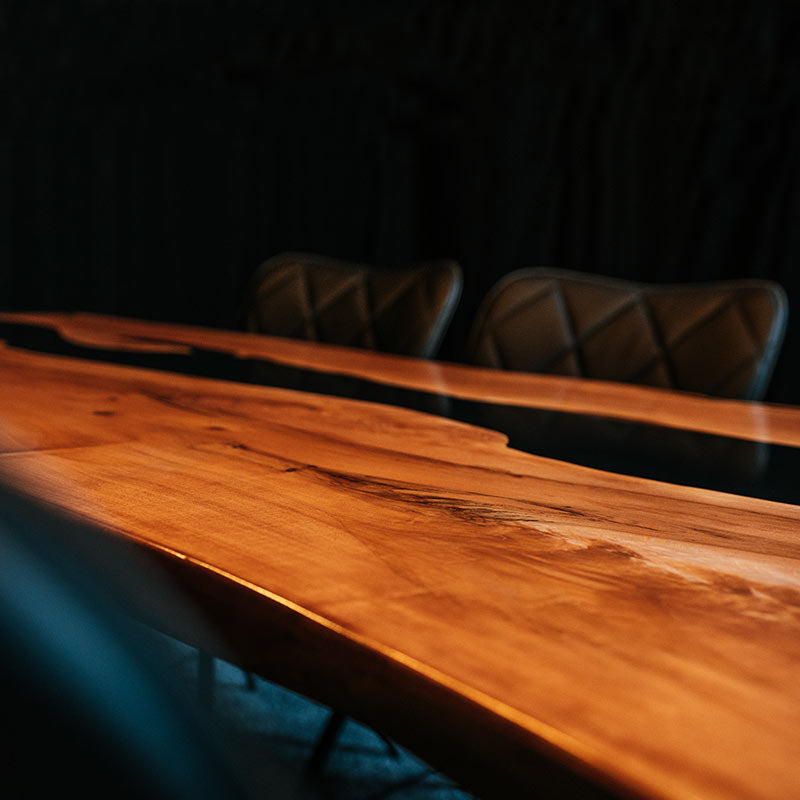 Epoxidharz Tisch aus Esche mit 6 schwarzen Stühlen auf blauem Teppich. Modell Hirschsprung von Schwarzhirsch