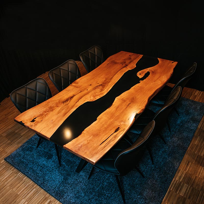 Epoxidharz Tisch aus Esche mit 6 schwarzen Stühlen auf blauem Teppich. Modell Hirschsprung von Schwarzhirsch