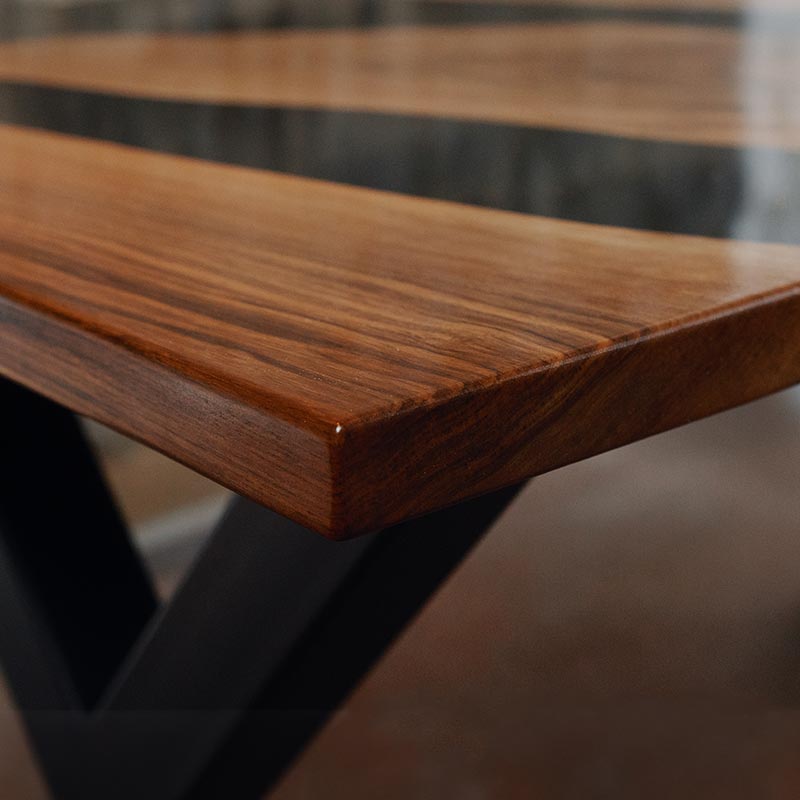 River Table. Detailbild von Epoxidharz Tisch aus Nussbaum mit gerader Baumkante. Modell Noyer von Schwarzhirsch.