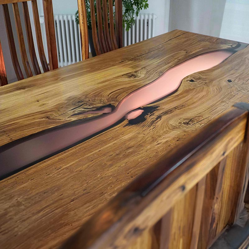 River Table. Esstisch Holz aus Eiche rustikal mit anthrazit farbenem Epoxidharz und Kreuzgestell von Schwarzhirsch