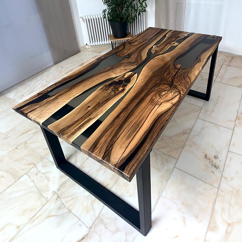 Epoxidharz Tisch. Esstisch aus Nussbaum mit transparentem Epoxidharz und Kreuzgestell. Modell Nussknacker von schwarzhirsch