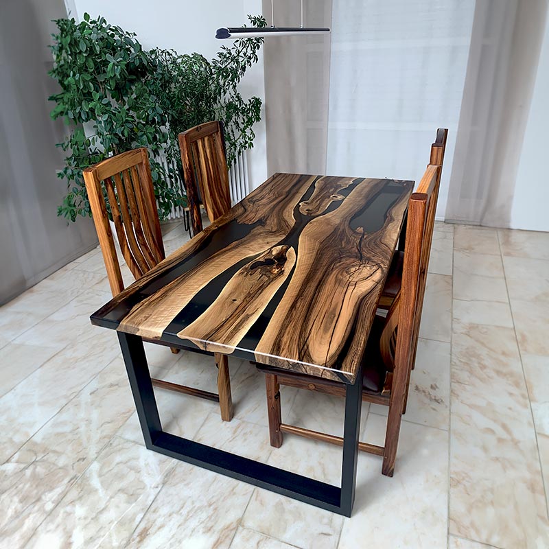 Epoxidharz Tisch. Bestuhlter Esstisch aus Nussbaum mit transparentem Epoxidharz und Kreuzgestell. Modell Nussknacker von schwarzhirsch