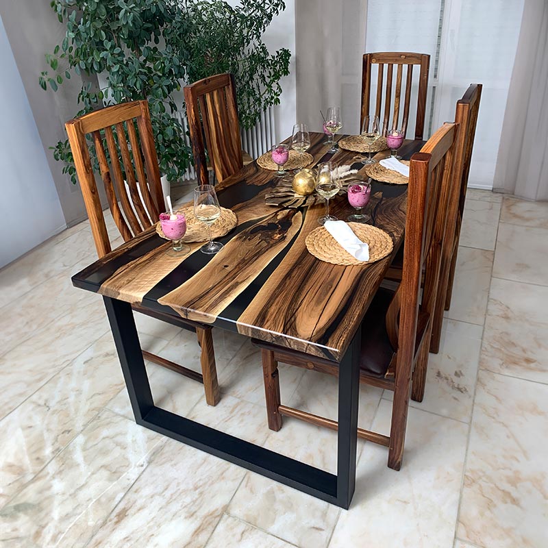 Epoxidharz Tisch. Dekorierter Esstisch aus Nussbaum mit transparentem Epoxidharz und Kreuzgestell. Modell Nussknacker von schwarzhirsch