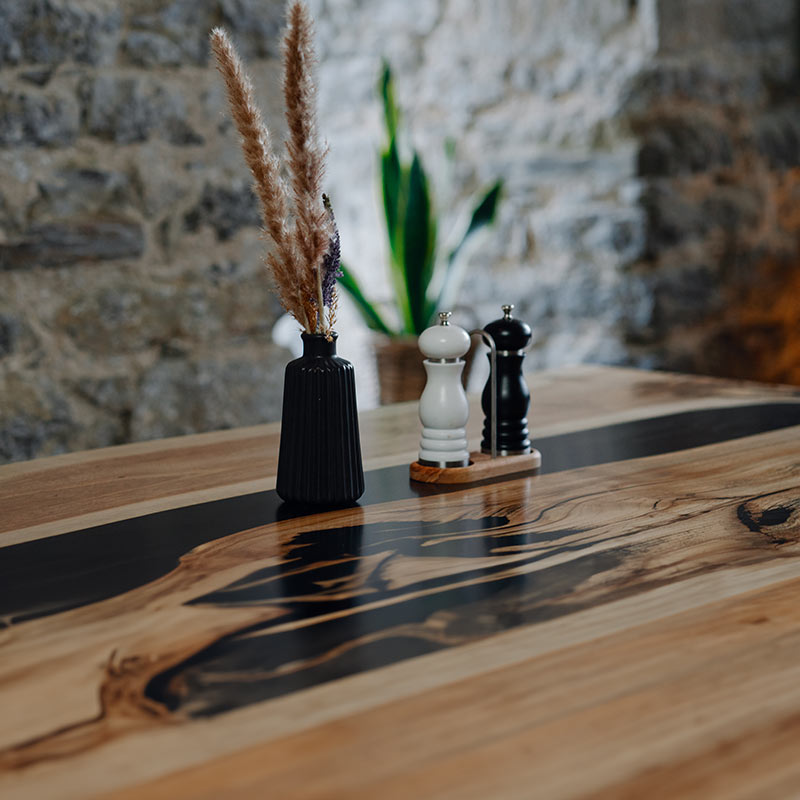 Dekorierter Epoxidharz Tisch aus Nussbaum schwarz mit Kreuzgestell. Modell Wutachschlucht von schwarzhirsch